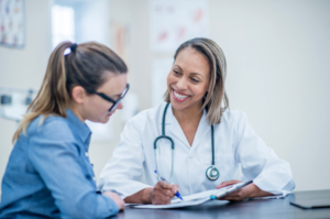 Female patient discussing urinary incontinence treatment options with her doctor, including referral to pelvic floor physical therapy in San Antonio