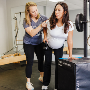 Pelvic floor therapist guiding a pregnant patient through personalized exercises tailored to her treatment protocol.