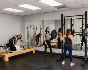 Two therapists guide patients through individualized workout routines designed to meet their unique needs.