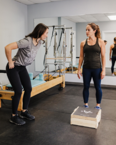 Physical therapist guiding a patient through proper core engagement during box jumps to avoid diastasis recti strain.